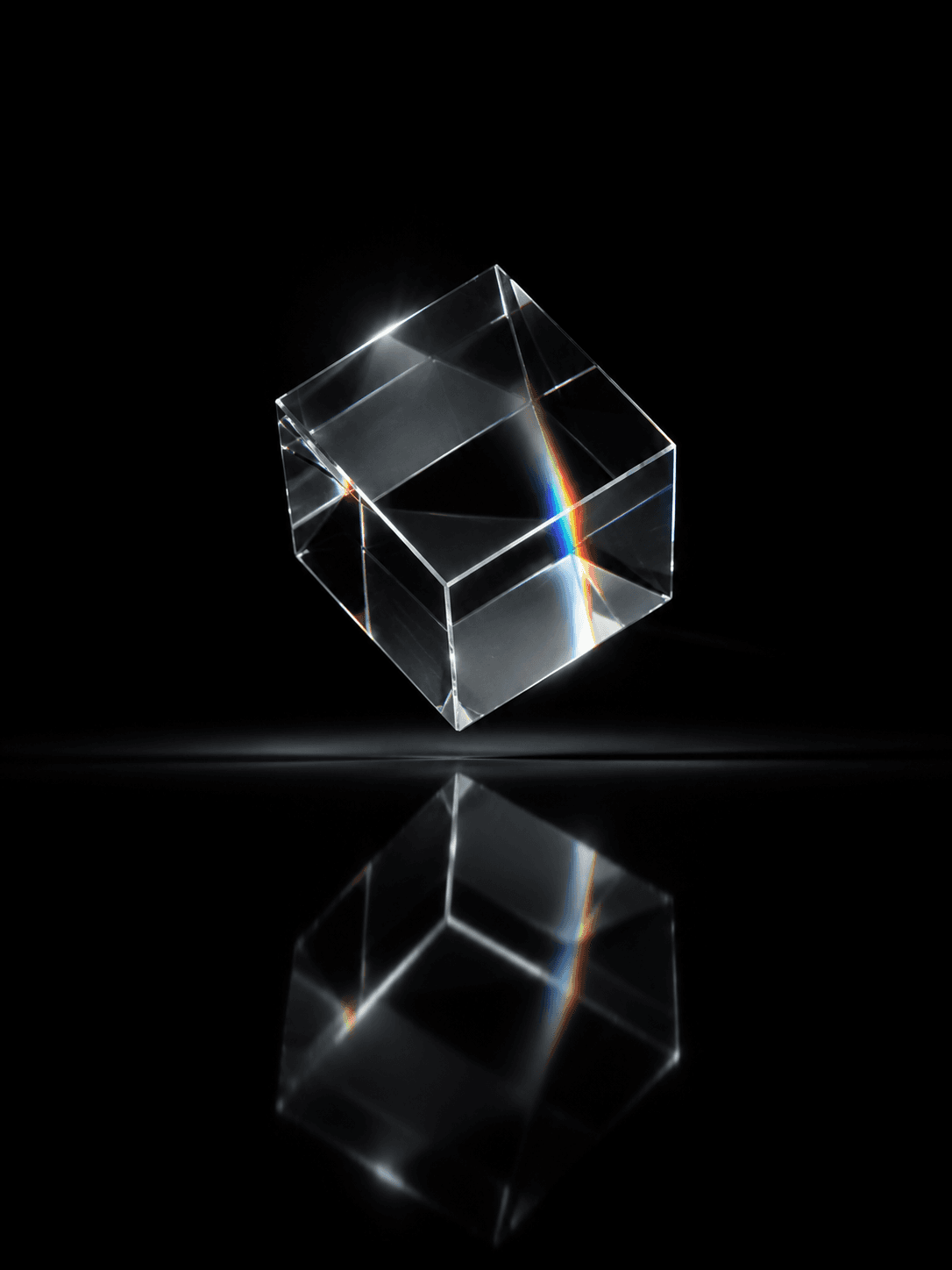 Cube de verre optique réfractant un spectre de lumière sur fond noir.